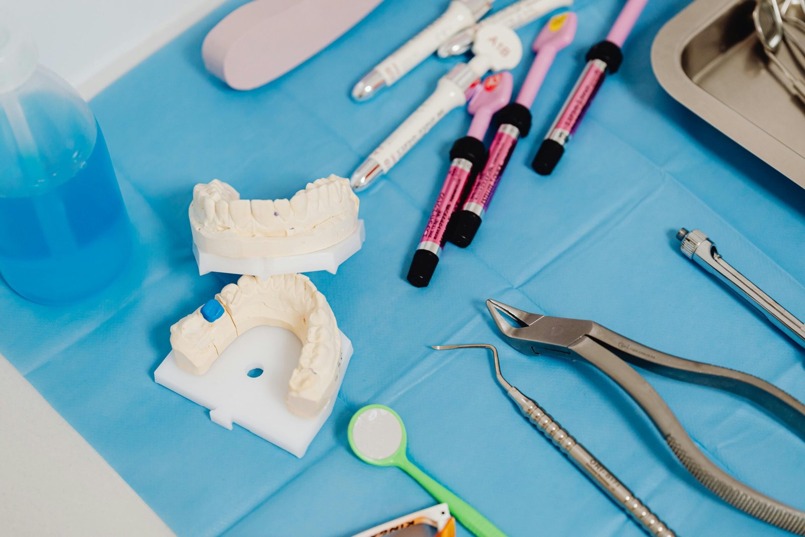 Close-up of dental instruments and tooth models on a clinic table for dental care procedures.